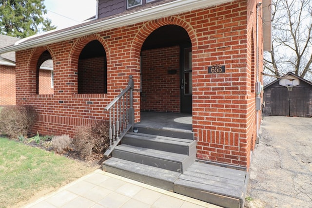 view of exterior entry with brick siding