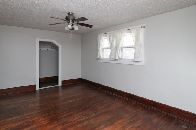 unfurnished room with a textured ceiling, baseboards, a ceiling fan, and hardwood / wood-style flooring