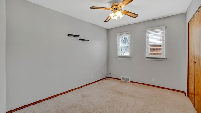 spare room featuring light carpet and ceiling fan