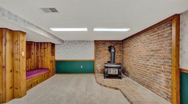 carpeted living room with a wood stove and a textured ceiling