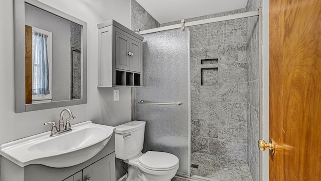 bathroom with a shower with shower door, toilet, and vanity