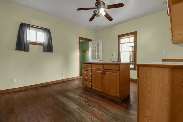 kitchen featuring dark hardwood / wood-style flooring, a kitchen island, ceiling fan, and sink