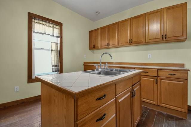 kitchen with a center island with sink, dark hardwood / wood-style flooring, sink, and tile countertops