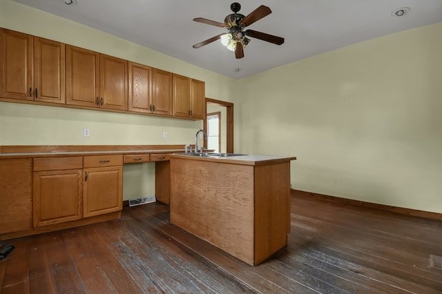 kitchen featuring kitchen peninsula, dark hardwood / wood-style flooring, ceiling fan, sink, and built in desk