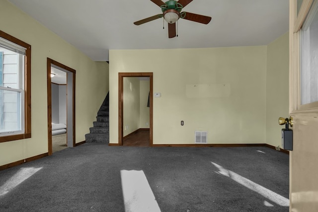 spare room with ceiling fan and dark carpet