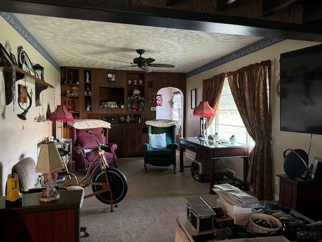 interior space with ceiling fan, wood walls, and a textured ceiling