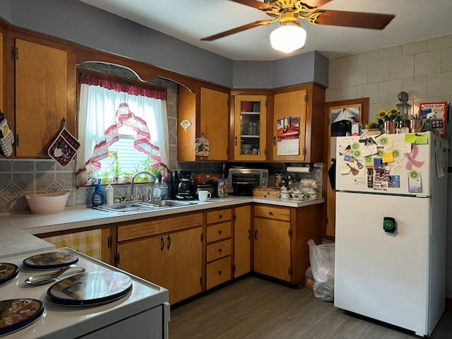 kitchen featuring sink, dark wood-type flooring, tasteful backsplash, white refrigerator, and stove