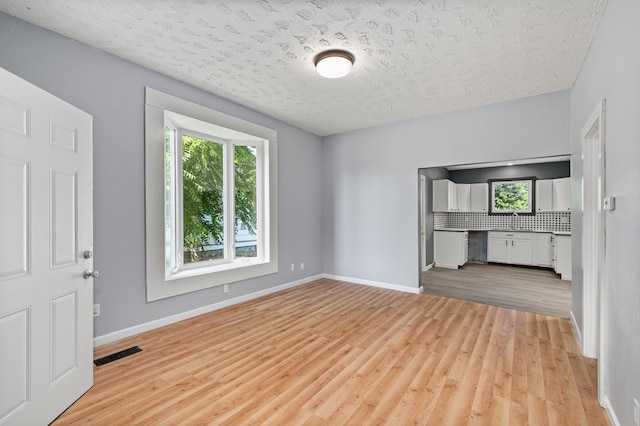 131 Sturges Ave, Mansfield, OH 44903 - unfurnished living room with light wood-style flooring and a textured ceiling