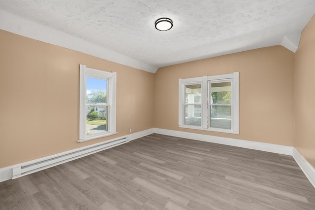 131 Sturges Ave, Mansfield, OH 44903 - empty room with a baseboard radiator, healthy amount of natural light, wood finished floors, a textured ceiling, and vaulted ceiling