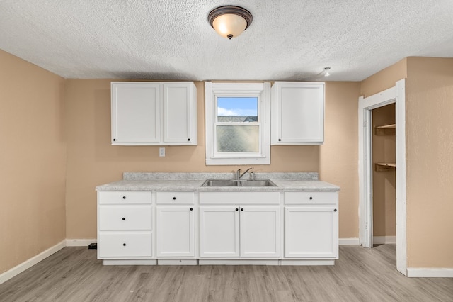 131 Sturges Ave, Mansfield, OH 44903 - kitchen with light wood finished floors, white cabinetry, a textured ceiling, and light countertops