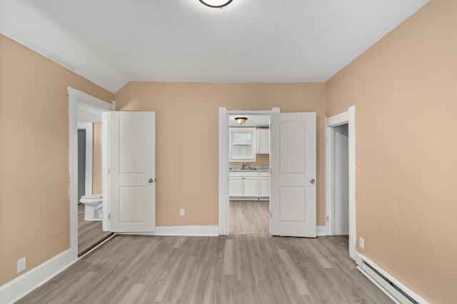 131 Sturges Ave, Mansfield, OH 44903 - unfurnished bedroom with baseboard heating, light wood-type flooring, ensuite bath, and lofted ceiling