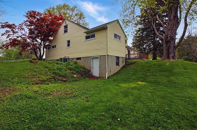 view of side of home with a lawn, central air condition unit, and a wooden deck