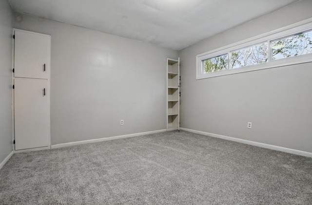 empty room with baseboards and carpet flooring