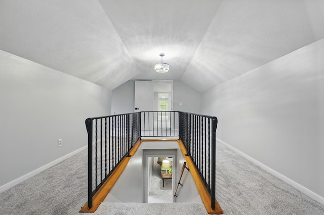 stairway with carpet flooring, baseboards, and lofted ceiling