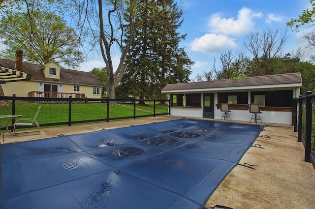 community pool featuring a lawn and fence