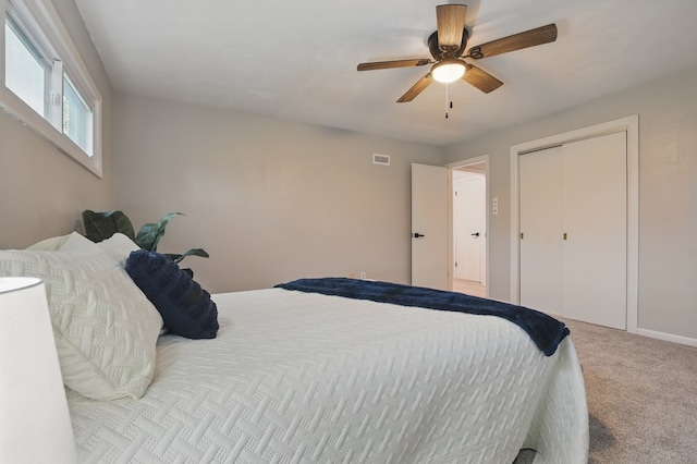 carpeted bedroom featuring baseboards, ceiling fan, a closet, and visible vents