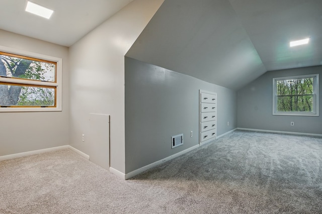 additional living space with carpet floors, vaulted ceiling, and plenty of natural light