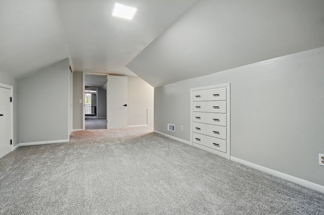 additional living space with carpet floors, baseboards, vaulted ceiling, and visible vents