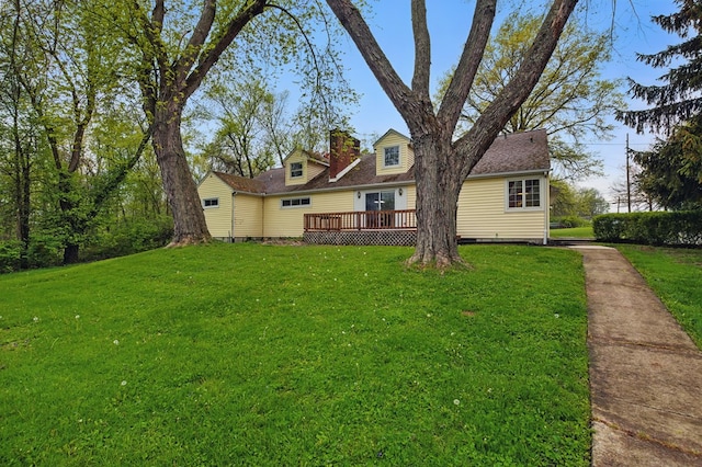 cape cod-style house featuring a front lawn, roof with shingles, a wooden deck, and a chimney
