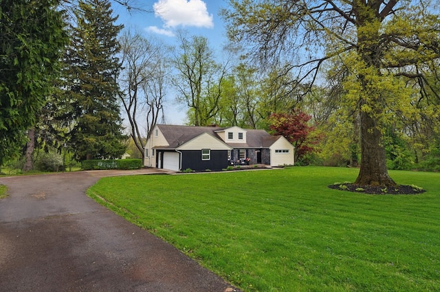 view of front of home featuring a garage, aphalt driveway, and a front yard
