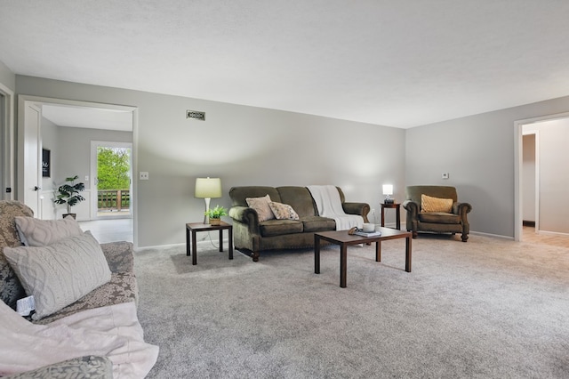 carpeted living room with visible vents and baseboards