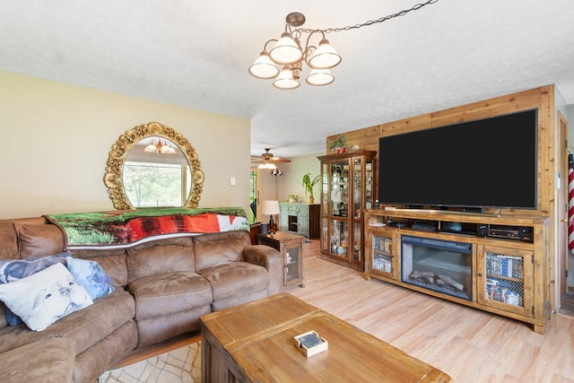 424 Day Rd, Mansfield, OH 44903 - living room with wood finished floors, a textured ceiling, a chandelier, ceiling fan, and a fireplace
