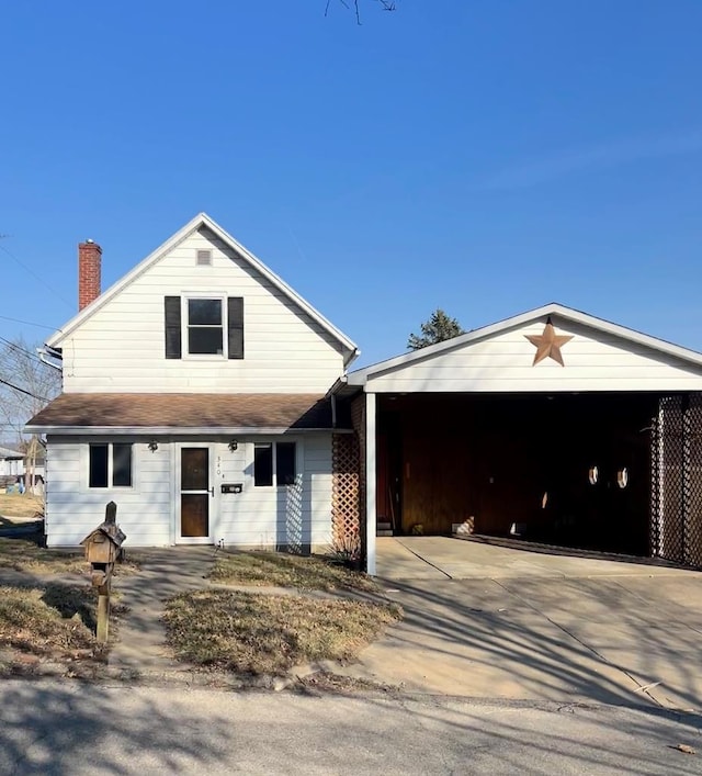 view of front of home featuring a garage, driveway, and a chimney