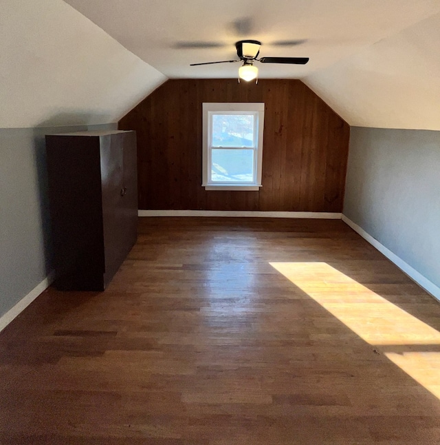 additional living space featuring lofted ceiling, wood finished floors, baseboards, and ceiling fan