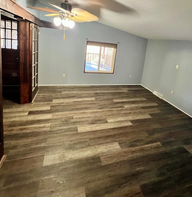 unfurnished room featuring a ceiling fan, lofted ceiling, wood finished floors, and visible vents