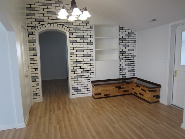 16 Earl Ave, Shelby, OH 44875 - unfurnished dining area with arched walkways, light wood-type flooring, a chandelier, and vaulted ceiling
