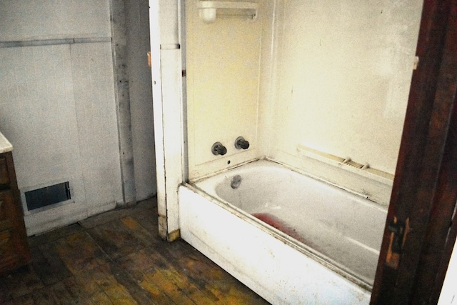 bathroom featuring hardwood / wood-style floors and a tub to relax in