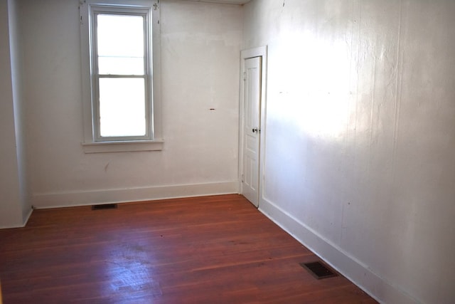 unfurnished room with dark wood-type flooring