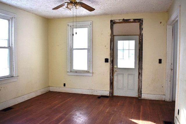 foyer featuring ceiling fan, dark wood-type flooring, and a textured ceiling