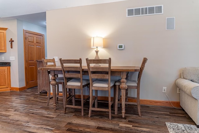 dining area featuring dark wood-style floors, visible vents, and baseboards