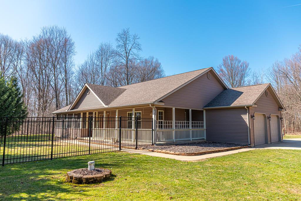 6340 US Highway 42, Mount Gilead, OH 43338 - single story home featuring a front lawn, fence, covered porch, driveway, and an attached garage