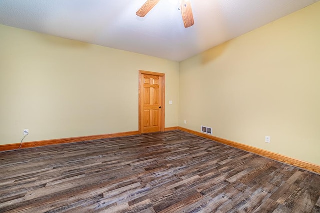 spare room with visible vents, baseboards, ceiling fan, and dark wood finished floors