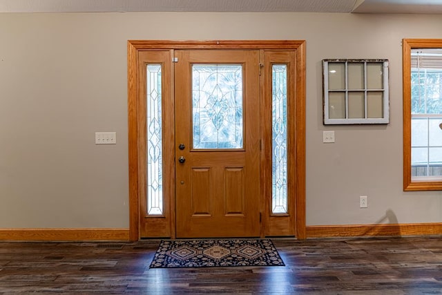 entryway with dark wood finished floors and baseboards