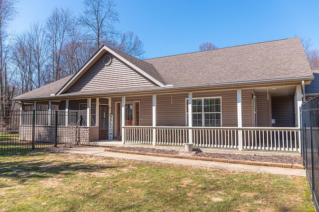 farmhouse with a porch, roof with shingles, a front lawn, and fence