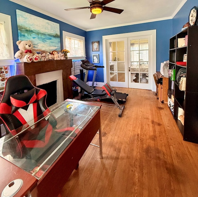 interior space with ornamental molding, a ceiling fan, and hardwood / wood-style floors