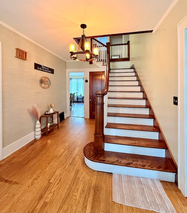 314 S Spring St, Bucyrus, OH 44820 - staircase with wood finished floors, a chandelier, ornamental molding, and baseboards
