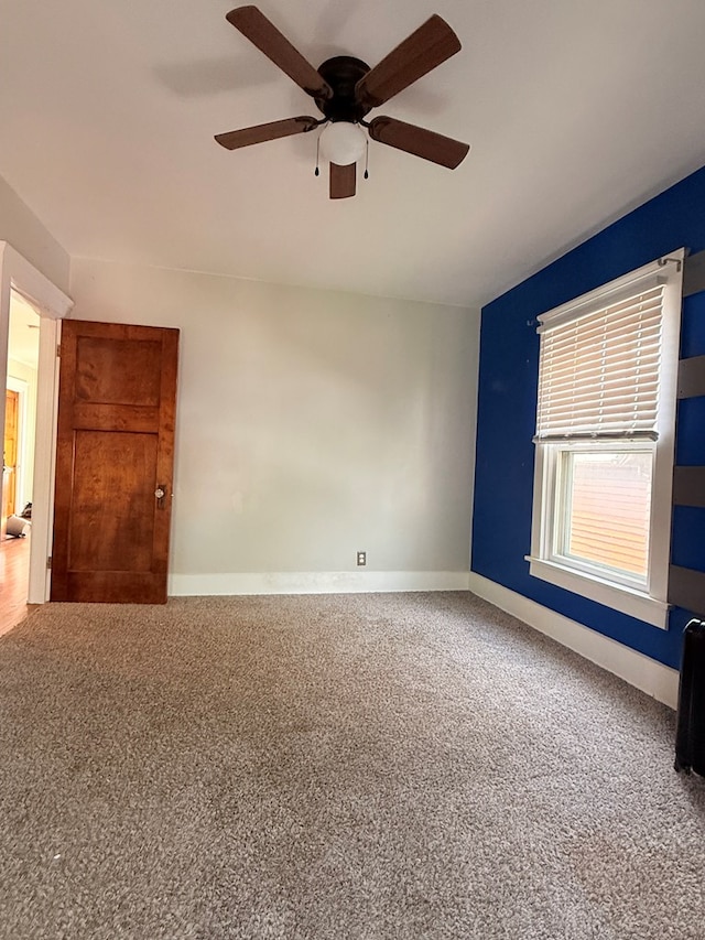 unfurnished room featuring ceiling fan, carpet flooring, and baseboards