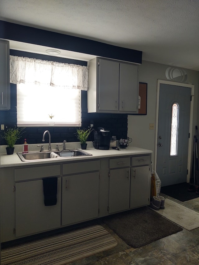 kitchen featuring a sink, a healthy amount of sunlight, and light countertops