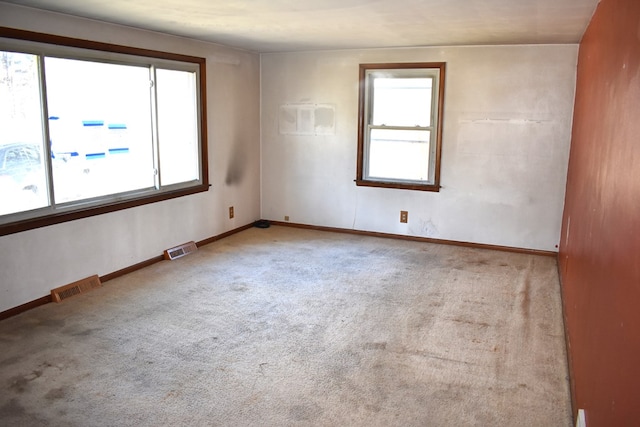 carpeted empty room with baseboards and visible vents