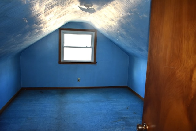 bonus room with vaulted ceiling, carpet floors, and baseboards