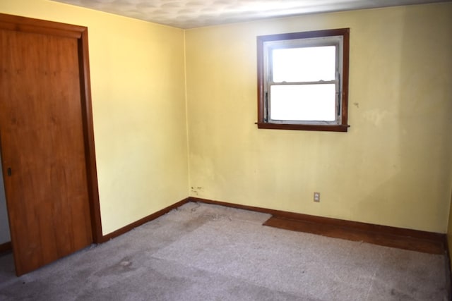 unfurnished room featuring carpet flooring and baseboards