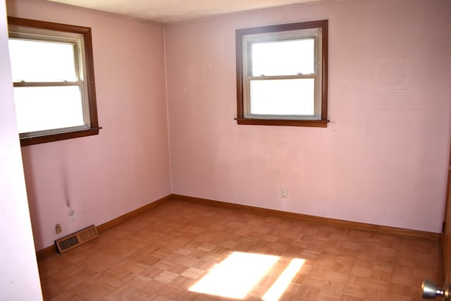 unfurnished room with visible vents and baseboards