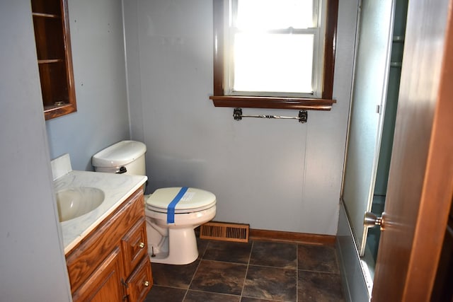 bathroom with baseboards, visible vents, toilet, walk in shower, and vanity