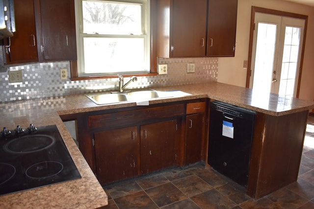 kitchen with tasteful backsplash, a peninsula, light countertops, black appliances, and a sink