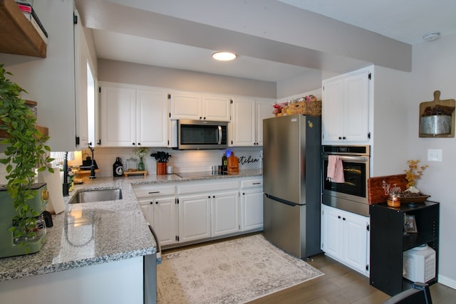 kitchen with white cabinets, tasteful backsplash, and stainless steel appliances