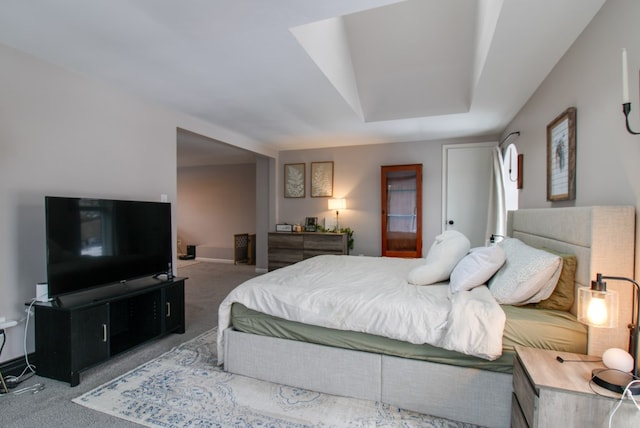 bedroom featuring carpet floors, a tray ceiling, and baseboards